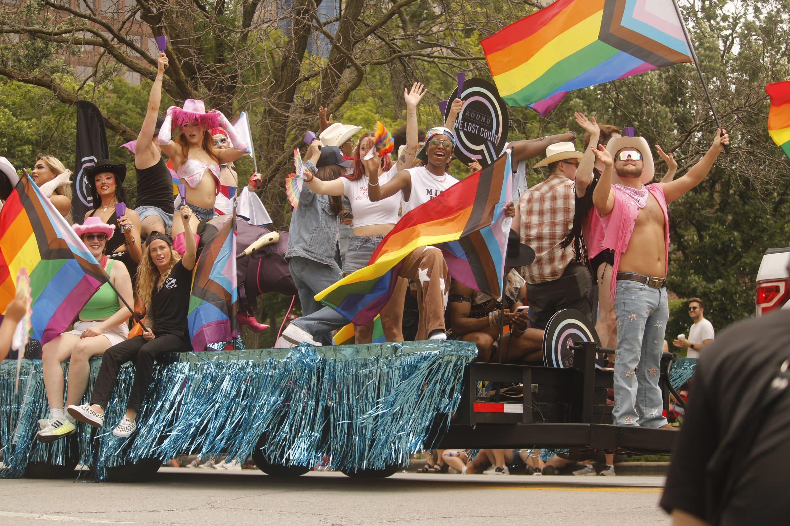 People on a float wave their flags during the PrideFest parade on June 6.