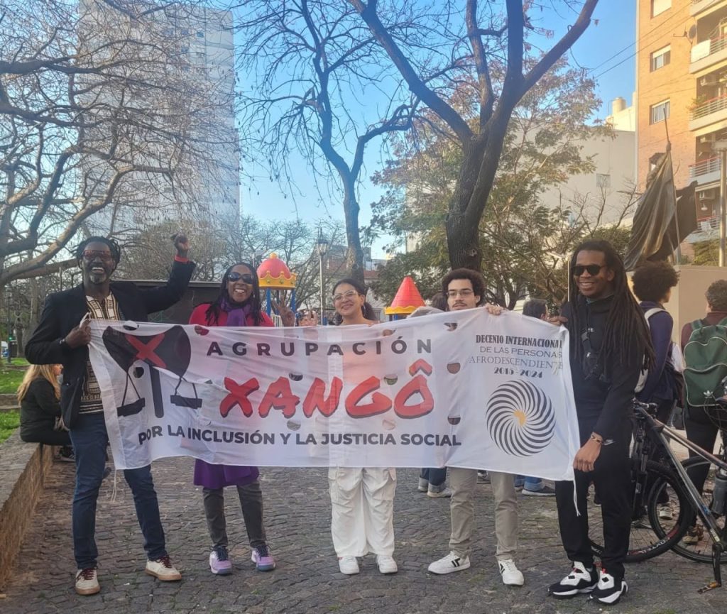 Members of Agrupacion Xango holding the organization's banner at a march