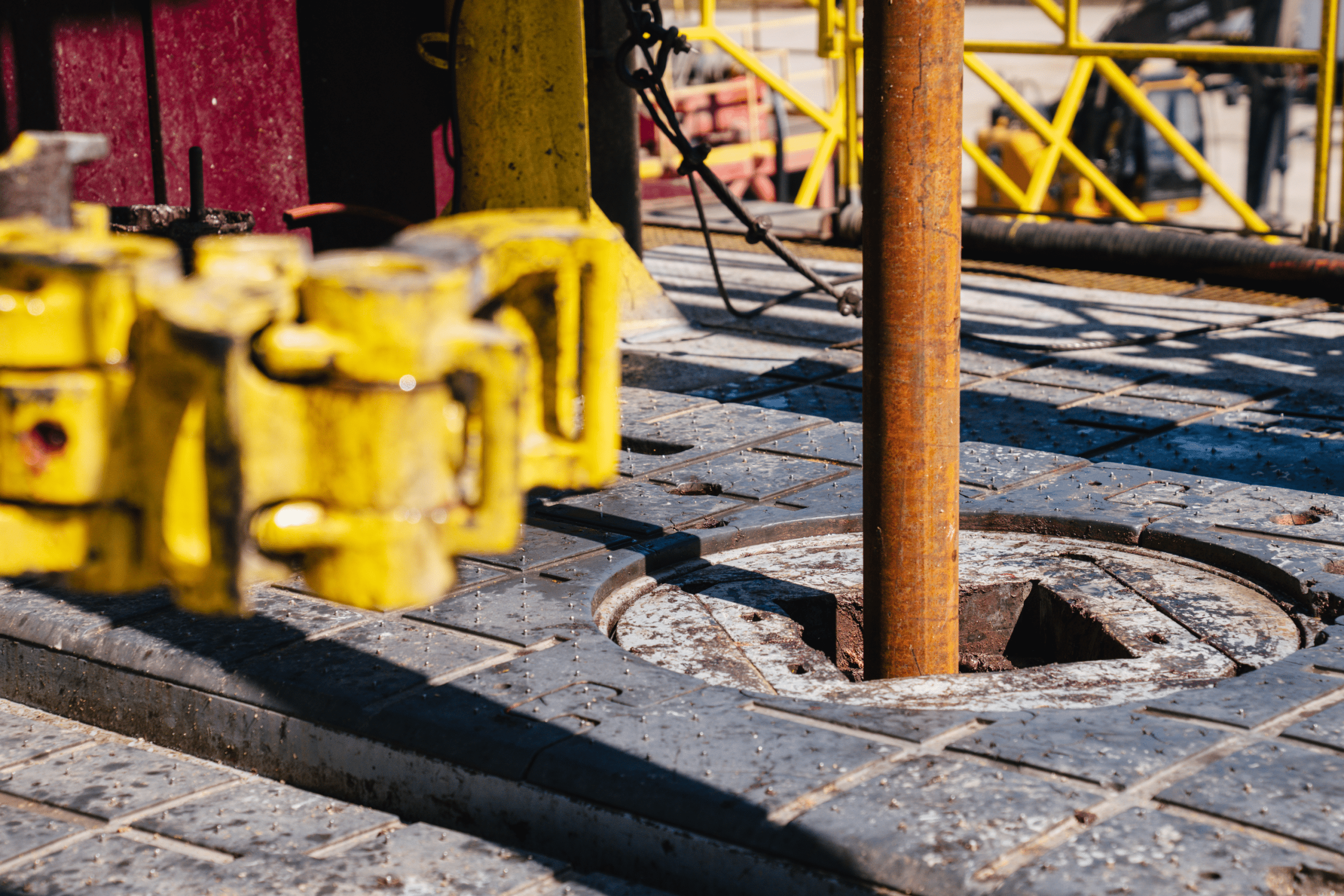 A drill pipe descends into the borehole opening.